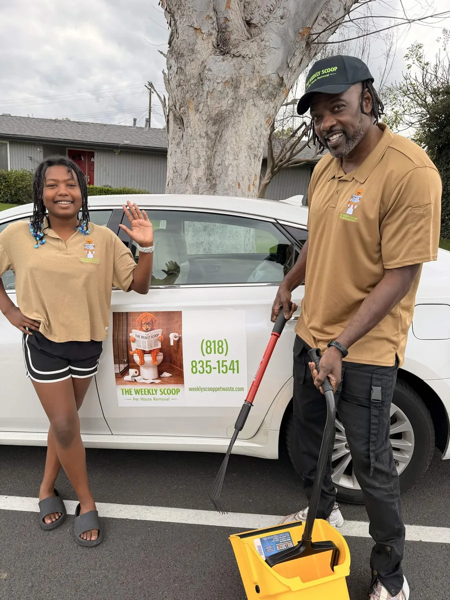 Malcolm and his daughter in matching Weekly Scoop polos beside the branded car